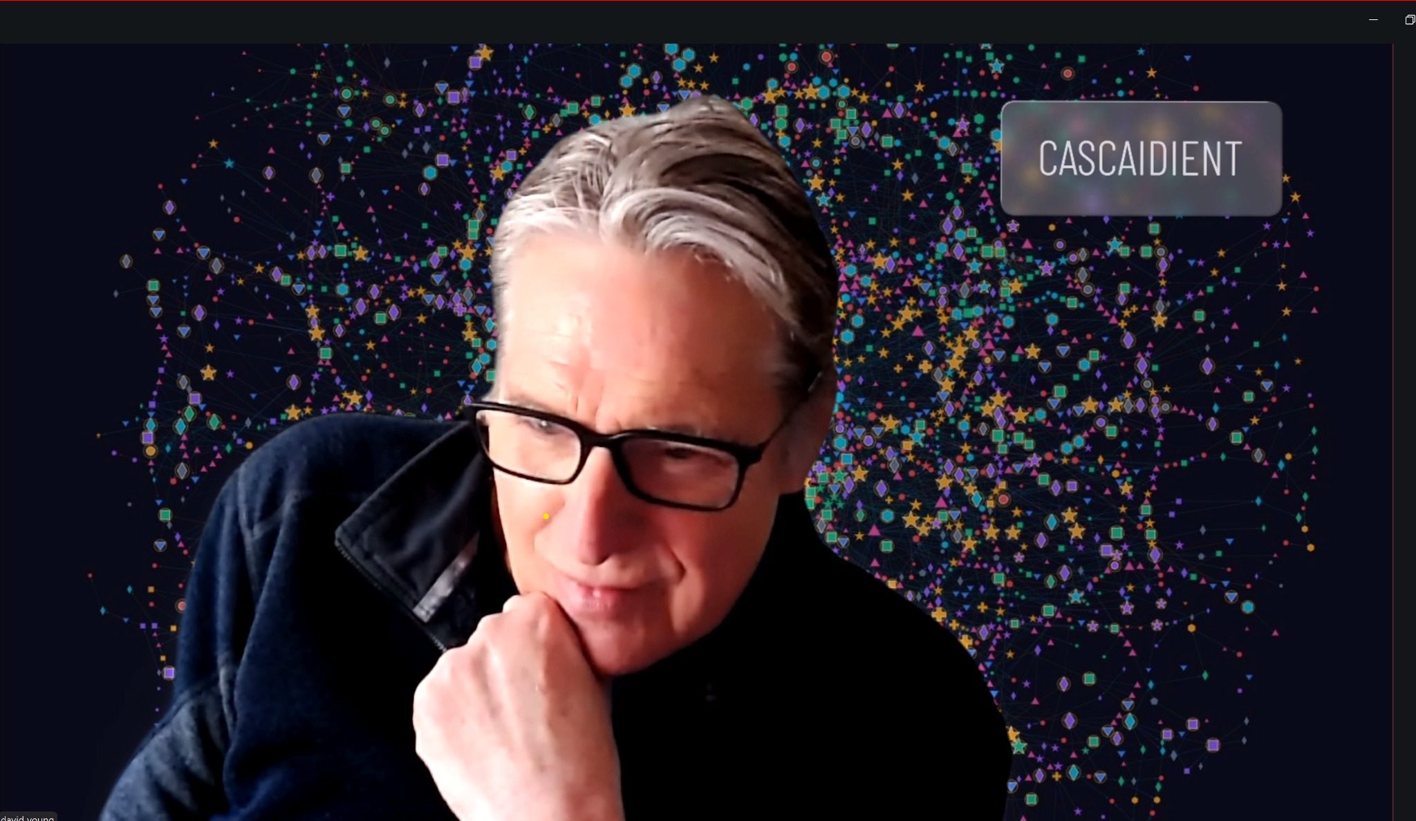 D. F. Young in front of a CASCAIDIENT industrial network visualization.